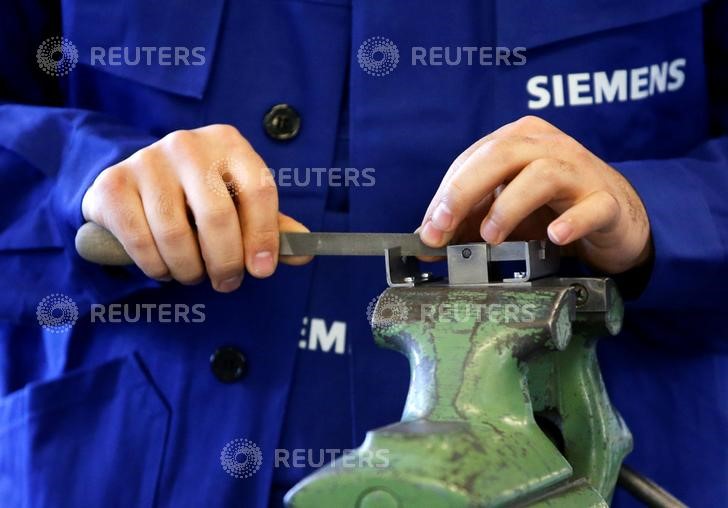 © Reuters. A refugee shows his skills in metal processing works during a media tour at a workshop for refugees organized by German industrial group Siemens in Berlin