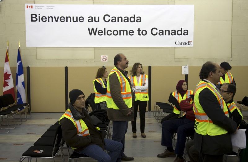 © Reuters. IRCC contractors including translators wait for the arrival of Syrian refugees at the Welcome Centre in Montreal