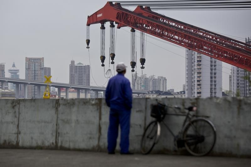© Reuters. A worker stands on a dock next to the Huangpu river in Shanghai