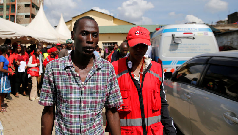 © Reuters. Ralson Saisi Wasike, pai de Dealeryn Saisi Wasike, ao lado de membro da Cruz Vermelha em Nairóbi