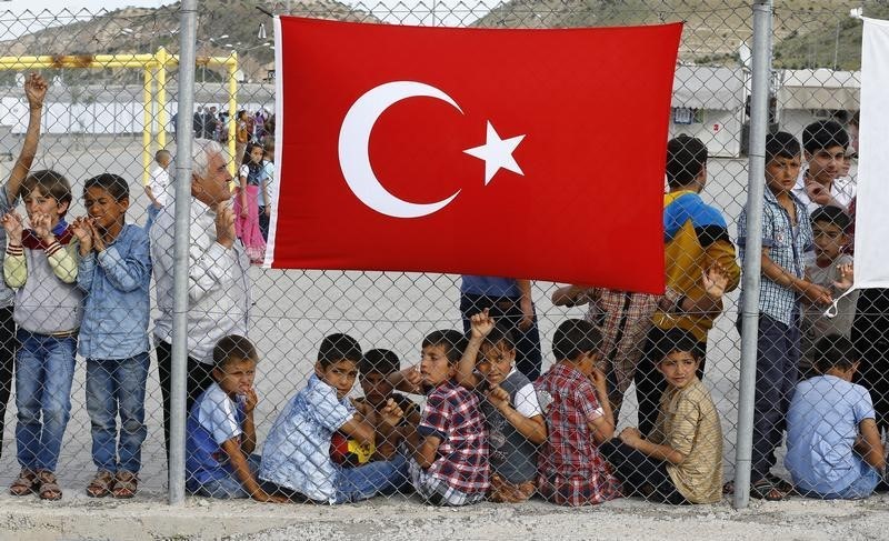 © Reuters. Refugees wait for the arrival of officals at Nizip refugee camp near Gaziantep