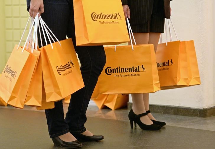 © Reuters. Hostesses distribute bags of German tyre company Continental before the shareholder meeting in Hanover,