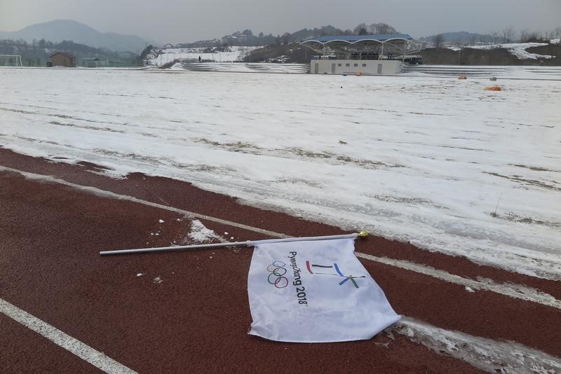 © Reuters. A flag lies on ground at proposed site of Olympic Stadium in PyeongChang
