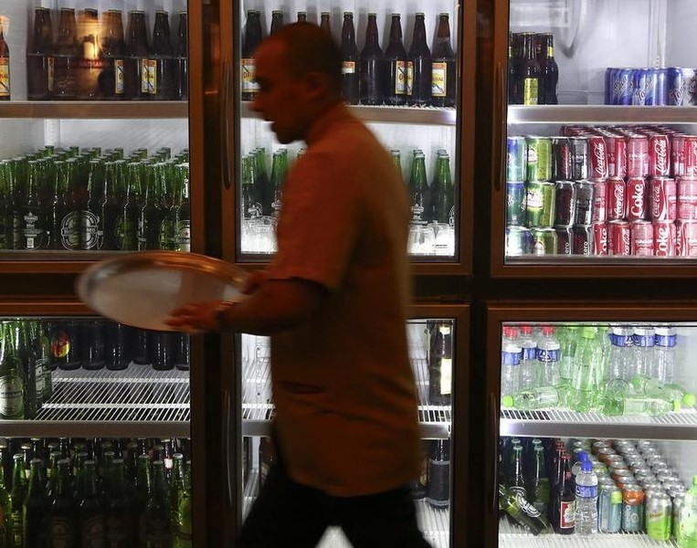© Reuters. Waiter passes in front of a refrigerator with drinks at 