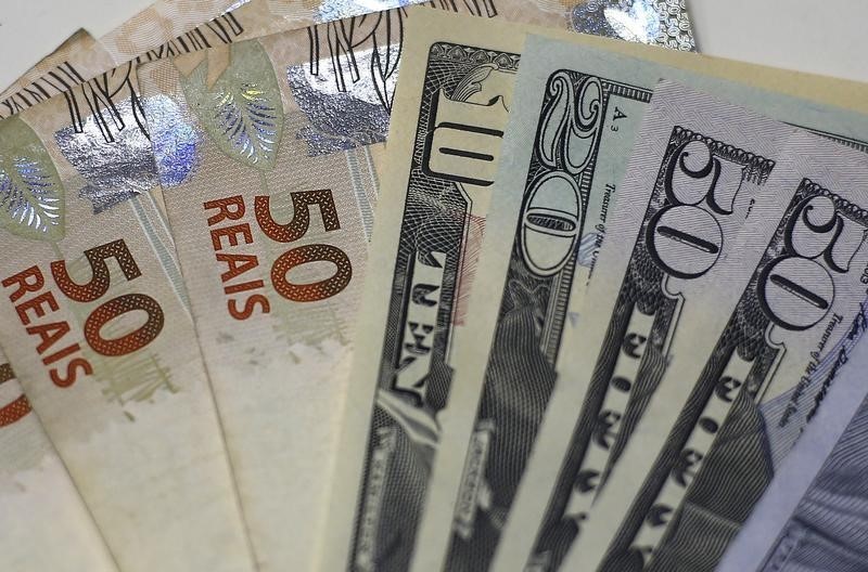 © Reuters. Brazilian Real and U.S. dollar notes are pictured at a currency exchange office in Rio de Janeiro