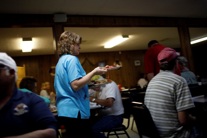 © Reuters. A waitress carries plates at a seafood restaurant in Bayou La Batre, Alabama