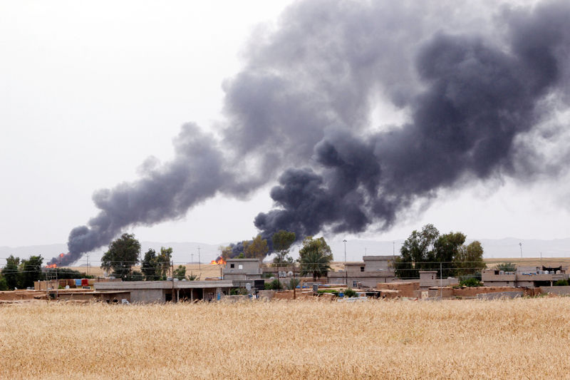 © Reuters. Smoke rises after explosions at two oil wells in Khabbaz oilfield, 20 km (12 miles) southwest of Kirkuk