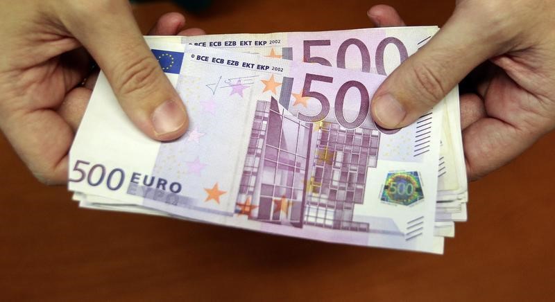 © Reuters. A bank employee holds a pile of 500 euro bank notes in Madrid