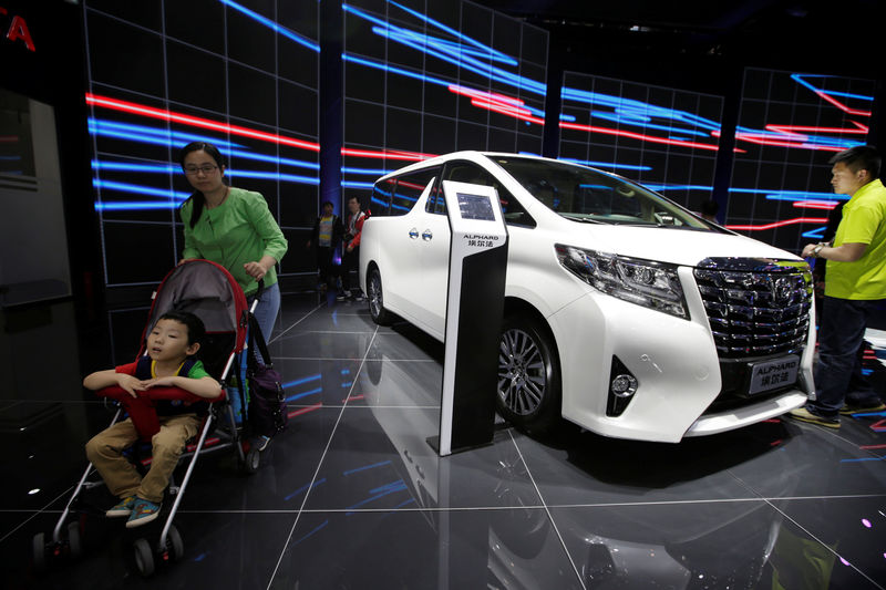 © Reuters. Visitors walk around a Toyota Alphard presented during the Auto China 2016 auto show in Beijing