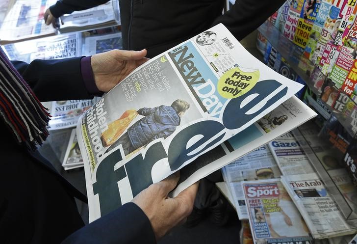 © Reuters. A customer holds a copy of the New Day at a newsagents in central London