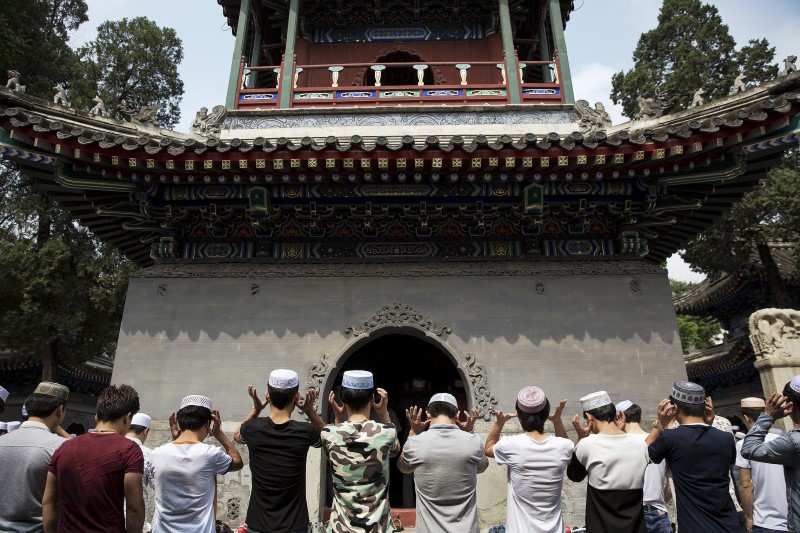 © Reuters. Muslim believers pray at the historic Niujie mosque as they celebrate the Eid al-Fitr in Beijing