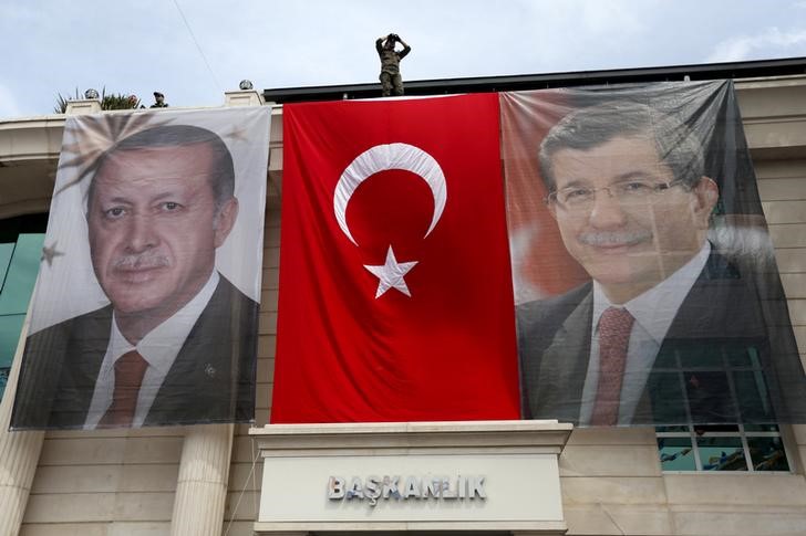 © Reuters. File photo of a special forces police officer taking security measures as he stands on top of a building where the portraits of Turkey's President Erdogan, Prime Minister Davutoglu and a Turkish flag are displayed in Istanbul