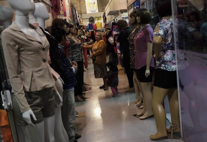 © Reuters. A Brazilian woman browses clothes at a shop of a Bolivian immigrant in the Bras neighbourhood of Sao Paulo