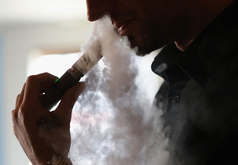 © Reuters. File photo of enthusiast Damien Hoops uses an electronic cigarette at The Vapor Spot vapor bar in Los Angeles