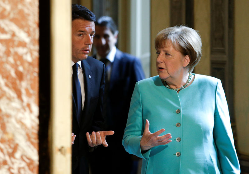 © Reuters. Italian Prime Minister Renzi talks with German Chancellor Merkel as they arrive for a news conference at Chigi Palace in Rome