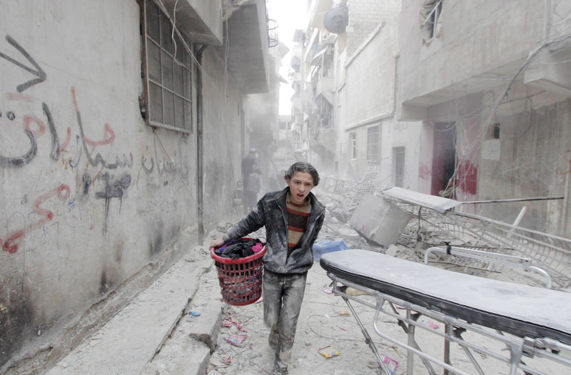 © Reuters. Menino carregando pertences após ataques na cidade síria de Aleppo