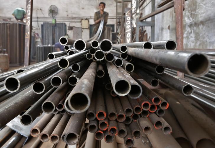 © Reuters. A worker stacks steel pipes in the western Indian city of Ahmedabad