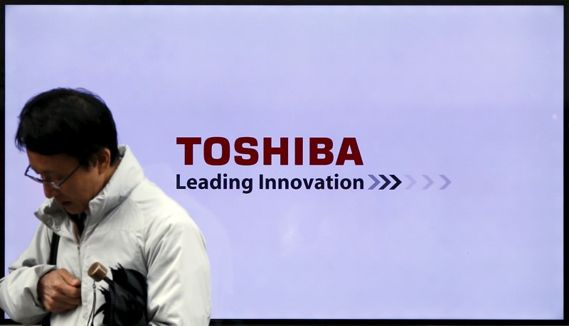 © Reuters. A man walks past a Toshiba Corp logo displayed on one of its television sets in Tokyo, Japan