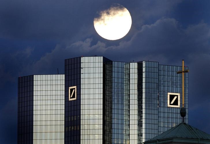 © Reuters. A rising full moon is seen over the distinctive twin towers of Germany's Deutsche Bank headquarters in Frankfurt 