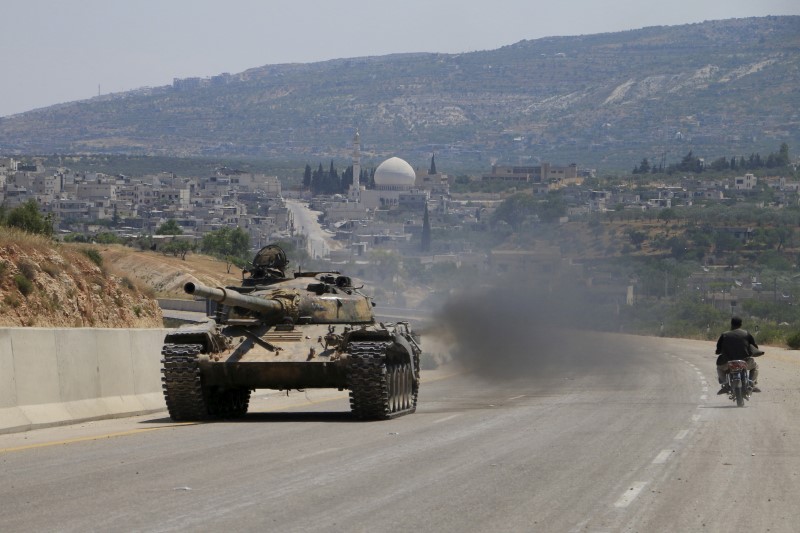 © Reuters. Jund al-Aqsa fighters part of a coalition of rebel groups called Jaish al Fateh, drive in a tank on a highway which connects Damascus to Aleppo, near Psoncol town after saying they had taken control of it