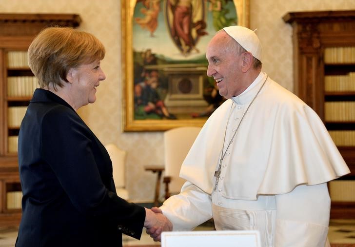 © Reuters. German Chancellor Merkel shakes hands with Pope Francis during a private audience before the 2016 Charlemagne Prize ceremony, at the Vatican