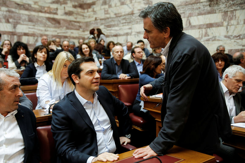 © Reuters. Greek PM Tsipras speaks with Finance Minister Tsakalotos before a ruling Syriza party parliamentary group session in Athens