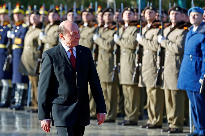 © Reuters. Romania's former President Basescu walks in front of the honour guard during a farewell ceremony at Cotroceni presidential palace in Bucharest