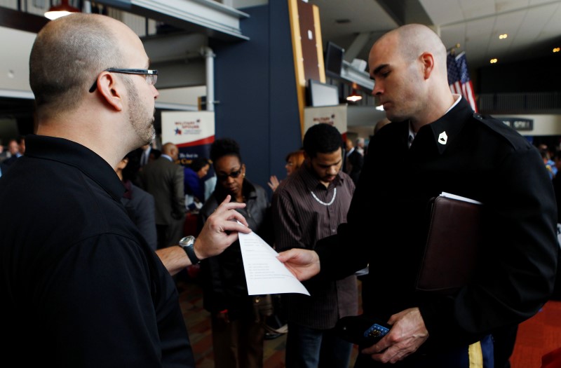 © Reuters. David Wallace of Lockheed Martin interviews an applicant at a job fair held by the U.S. Chamber of Commerce and the Washington Nationals baseball club in Washington