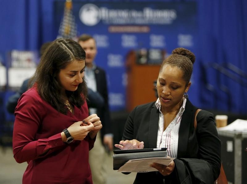 © Reuters. Job applicant has resume looked at during "Hiring Our Heroes" military job fair in Washington