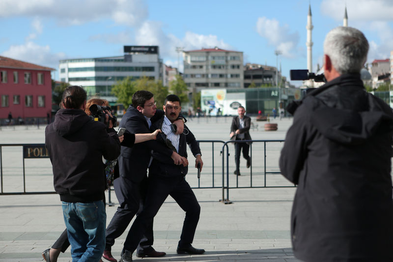 © Reuters. An assailant who attempted to shoot prominent Turkish journalist Can Dundar is caught by Dilek Dundar, wife of Can Dundar, and an unidentified man outside a courthouse in Istanbul