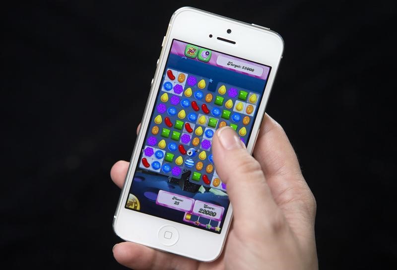 © Reuters. A woman poses for a photo illustration with an iPhone as she plays Candy Crush in New York