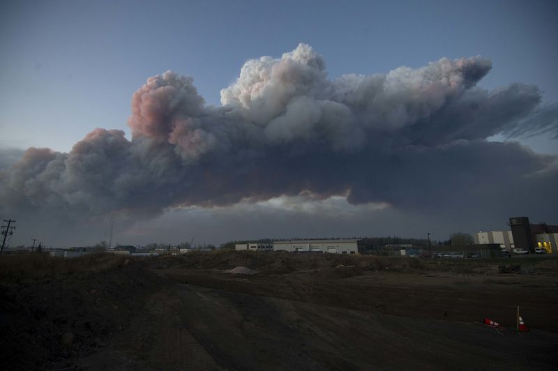 © Reuters. A massive plume of smoke from a wildfire north of the city stretches over Fort McMurray Alberta