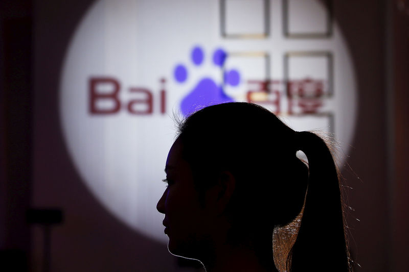 © Reuters. A woman is silhouetted against the Baidu logo at a new product launch from Baidu, in Shanghai, China