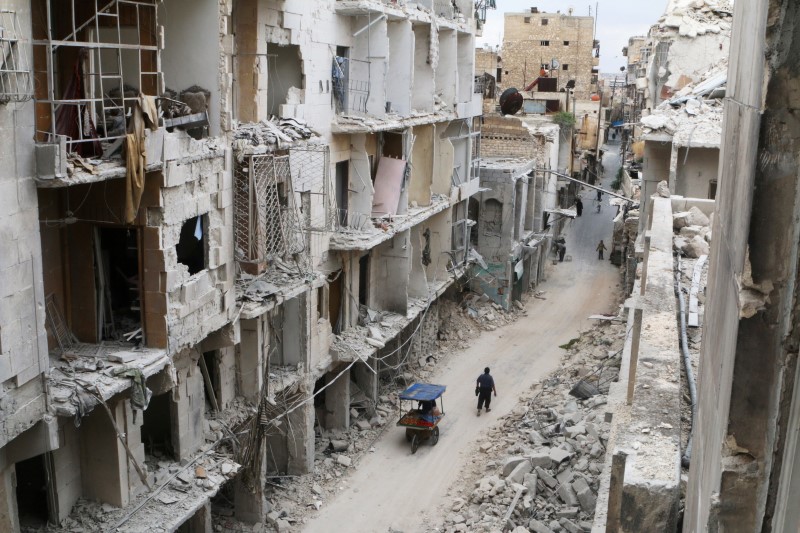 © Reuters. Residents walk near damaged buildings in the rebel held area of Old Aleppo