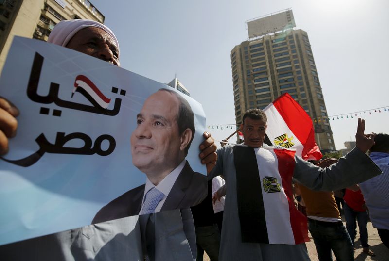 © Reuters. A supporter of Egypt's army and Egyptian President Abdel Fattah al-Sisi holds a poster with Sisi's picture during the anniversary of Sinai Liberation Day celebrations in Cairo