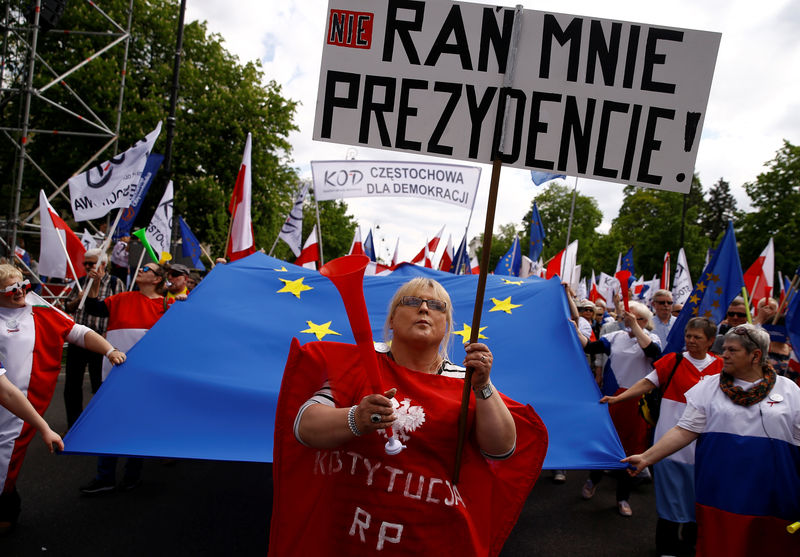 © Reuters. A woman holds a sign as she marches during an anti-government demonstration organised by main opposition parties in Warsaw