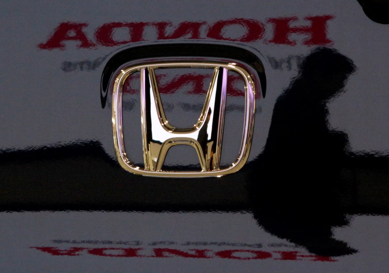 © Reuters. Visitor and logo of Honda Motor Co are reflected on a Honda car at company headquarters in Tokyo