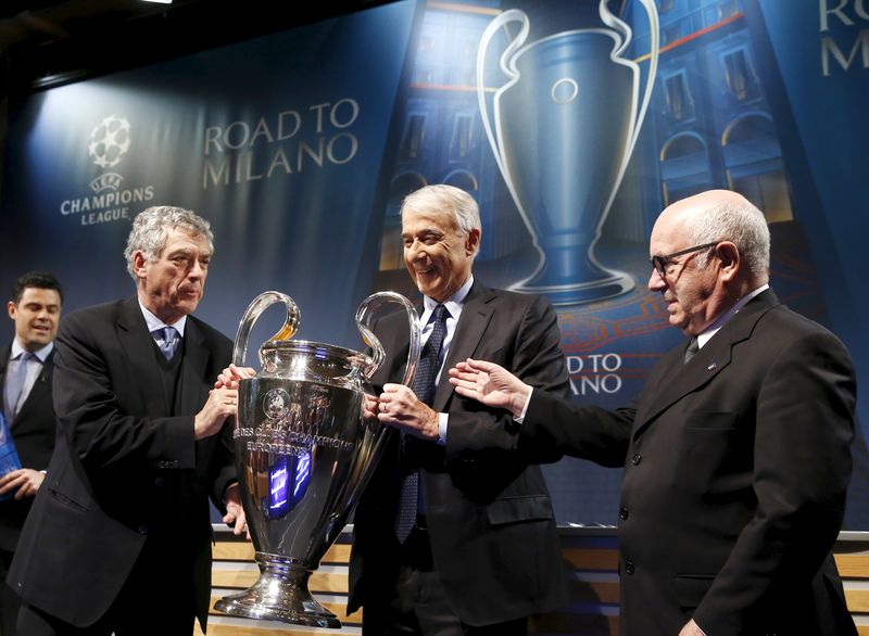 © Reuters. UEFA Vice-President Villar Llona of Spain gives the trophy to Pisapia Mayor of Milano and Tavecchio Chairman of the Italian Football Association after the draw of Champions League semi finals in Nyon