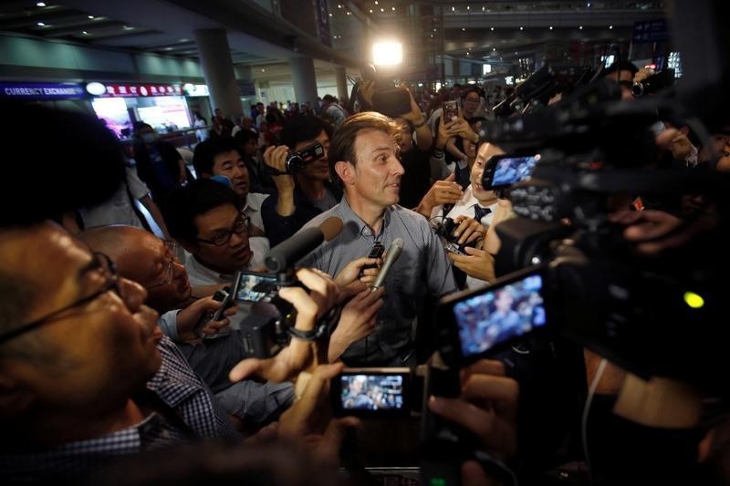 © Reuters. BBC journalist Rupert Wingfield-Hayes is surrounded by reporters upon his arrival at Beijing Capital International Airport after being expelled from North Korea, in Beijing
