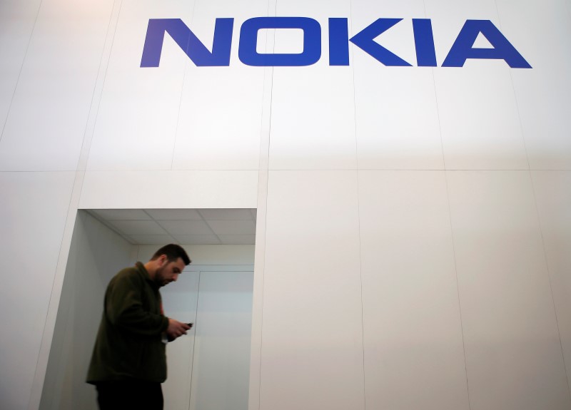 © Reuters. A man walks past the Nokia stand while attending the Mobile World Congress in Barcelona