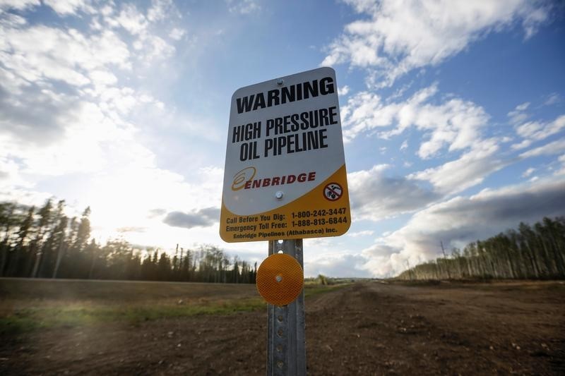 © Reuters. An Enbridge high pressure oil pipeline sign stands as smoke billows from the Fort McMurray in Kinosis