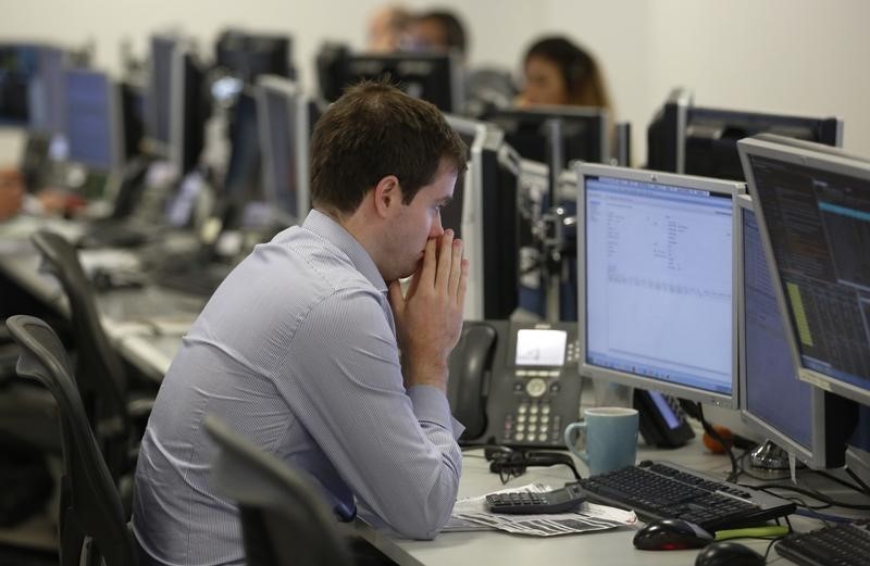 © Reuters. A trader sits at his desk at IG Index in London