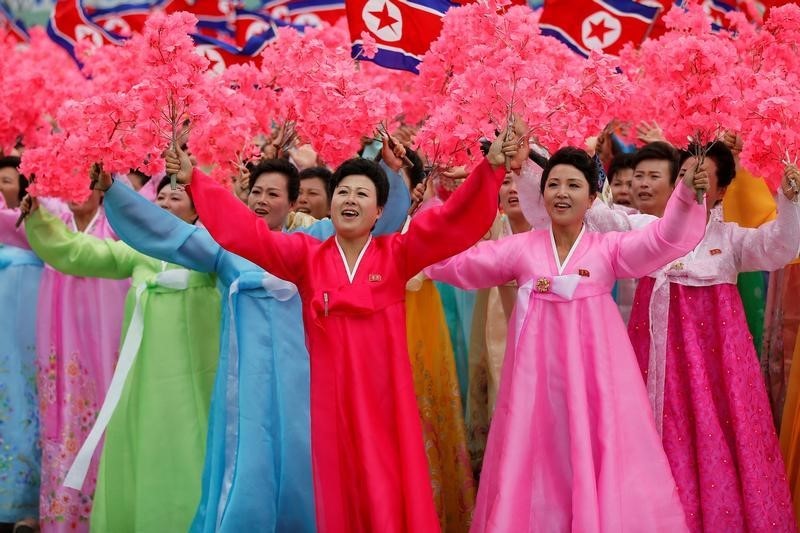 © Reuters. People react as they see North Korean leader Kim Jong Un during a mass rally and parade in Pyongyang