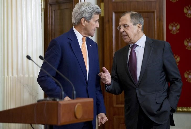 © Reuters. Russian Foreign Minister Sergei Lavrov speaks to U.S. Secretary of State John Kerry as they arrive for a news conference at the Kremlin in Moscow, Russia