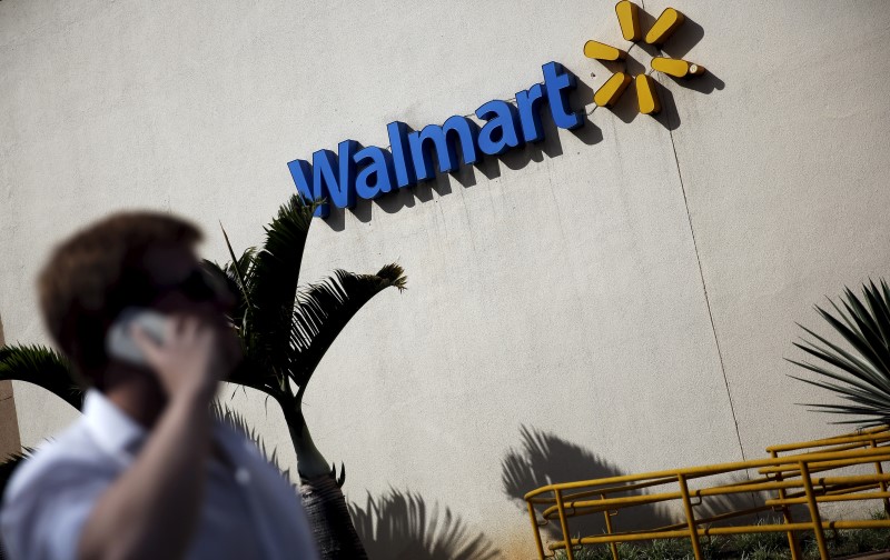 © Reuters. A man talks on his mobile phone in front of a Wal-Mart store in Sao Paulo