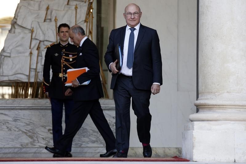 © Reuters. French Finance Minister Michel Sapin and Foreign Affairs Minister Laurent Fabius leave the Elysee Palace following the weekly cabinet meeting in Paris