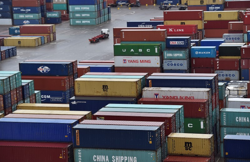 © Reuters. File photo of a transporter lorry driving between shipping containers stacked at the port of Felixstowe in Britain