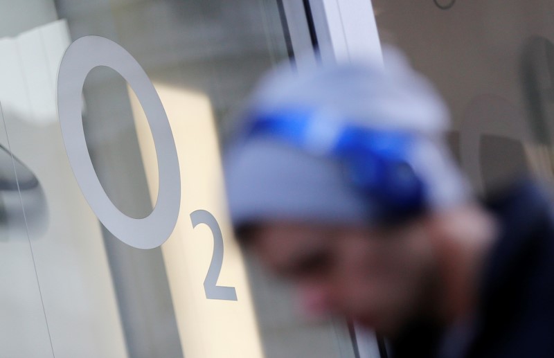 © Reuters. A pedestrian walks past an O2 mobile phone shop in central London