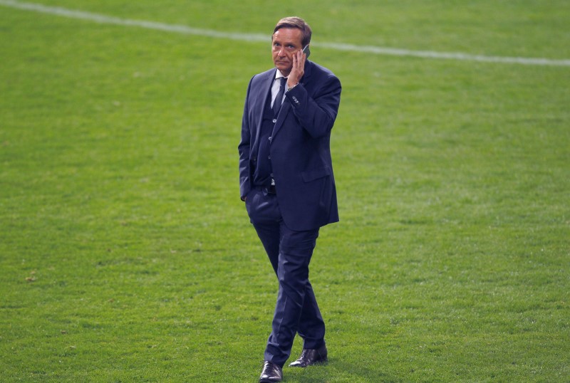 © Reuters. Schalke 04's manager Heldt listens at his mobile phone after the Bundesliga first division soccer match against Hertha Berlin in Gelsenkirchen