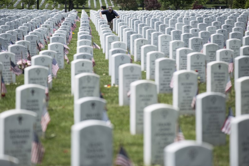 © Reuters. A man pauses at a grave during Memorial Day celebrations at Arlington National Cemetery
